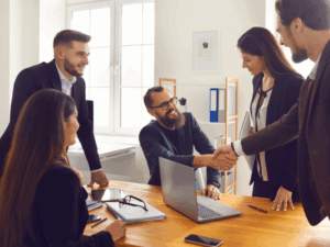 Equipos mixtos interno-externo colaborando en transferencia de conocimiento durante proyecto de outsourcing