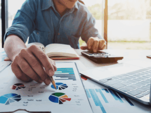 Profesional analizando presupuesto TI con gráficos y calculadora para PyME