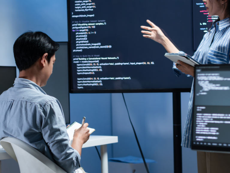 Desarrolladores revisando y traspasando código fuente durante proyecto de outsourcing de software