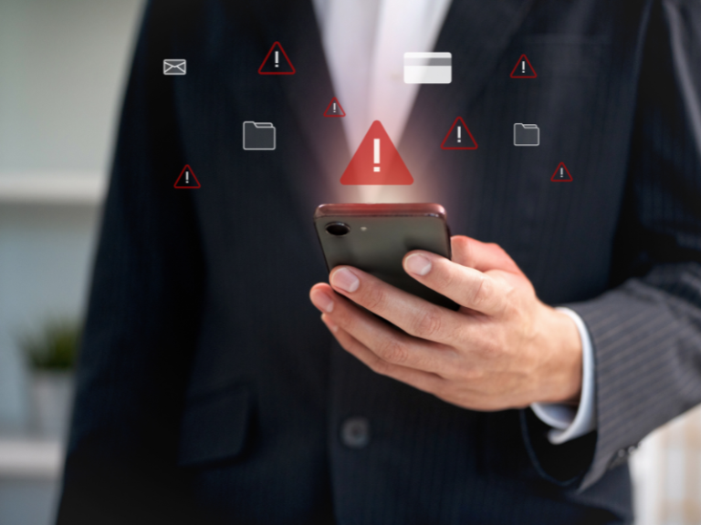 Ejecutivo sosteniendo smartphone rodeado de íconos de alerta roja: notificación de incidente de seguridad de datos personales