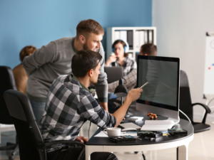 Equipo de especialistas tecnologicos revisando codigo en pantalla durante un proyecto de staffing TI