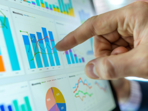 Mano señalando un gráfico de barras en un dashboard con indicadores operacionales